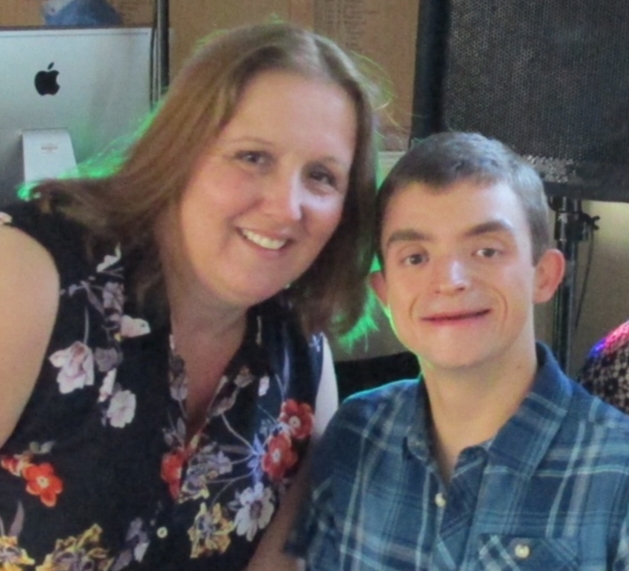 A mum and her son smiling together in the living room,