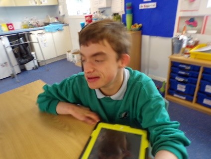 A young man at a desk at school.