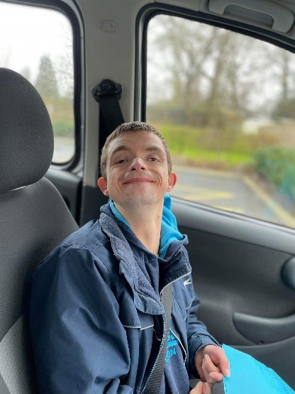 A young man smiling in a car.